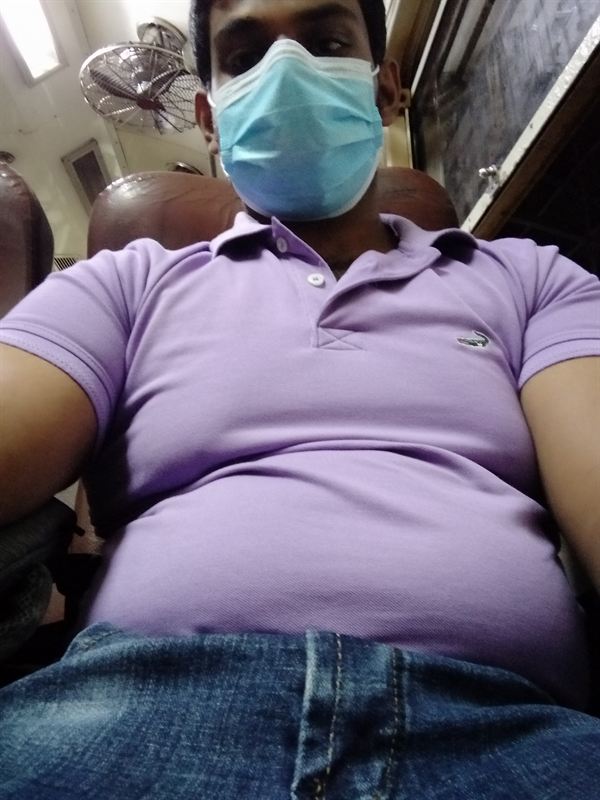 Haritha before, in a purple polo and a face mask