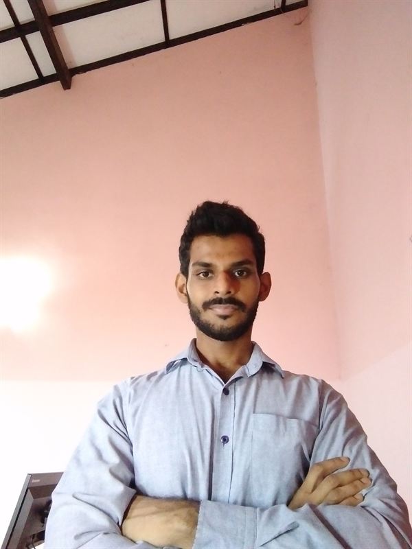 Haritha after, in an office shirt with arms crossed